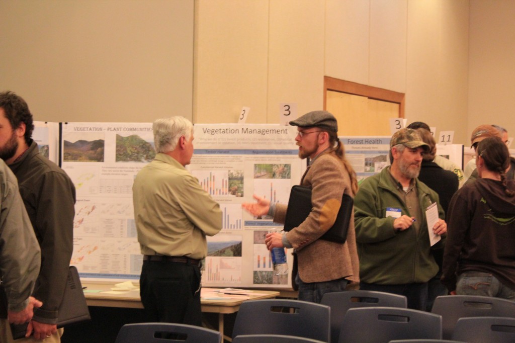Henderson, who led the class, examined the post boards and spoke with other community members.  Photo by Brandy Carl.